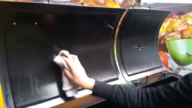 This image show oil being while over the door during the offset smoker seasoning process