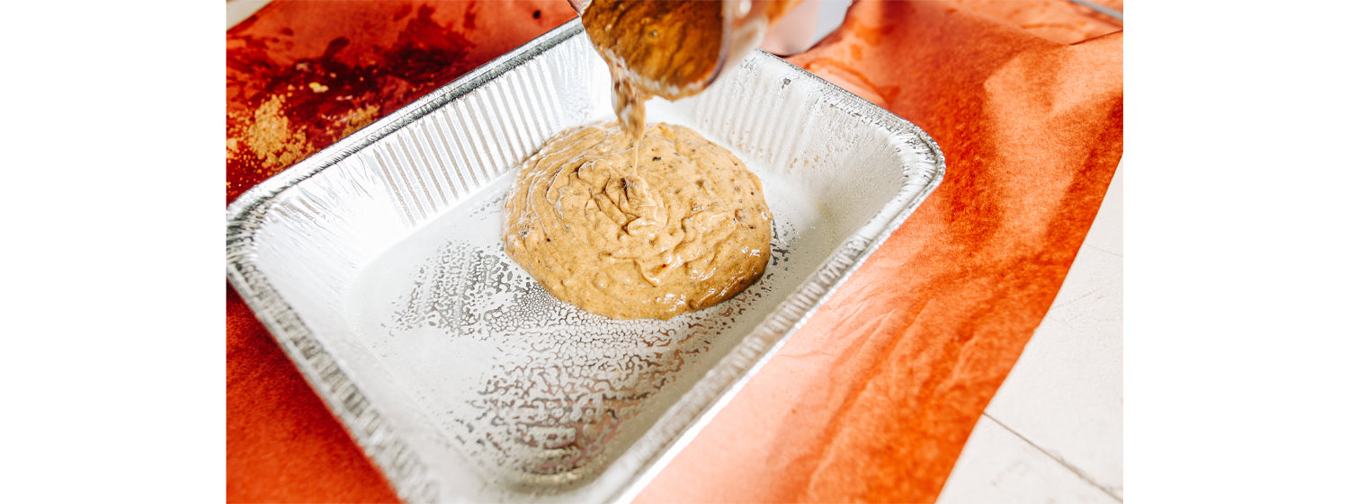 This image shows a sticky date pudding mixture poured  in the aluminum tray