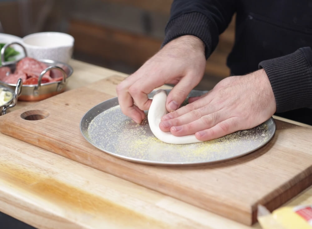 This image shows stretching pizza dough