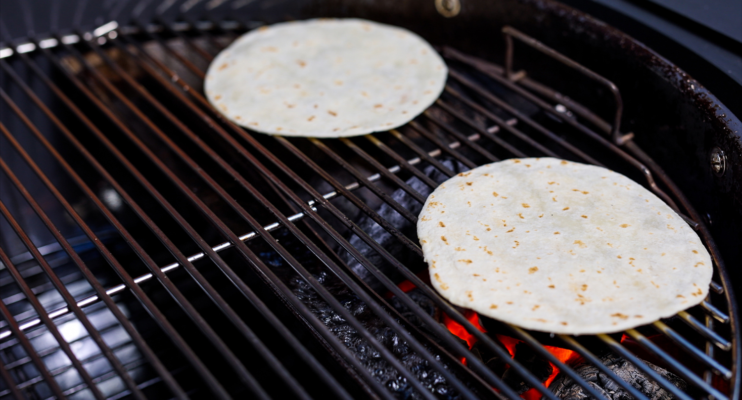 This image shows two pieces of tortilla place on kettle grill