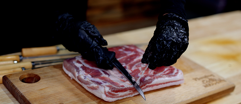 This image shows excess fat of pork belly being trimmed