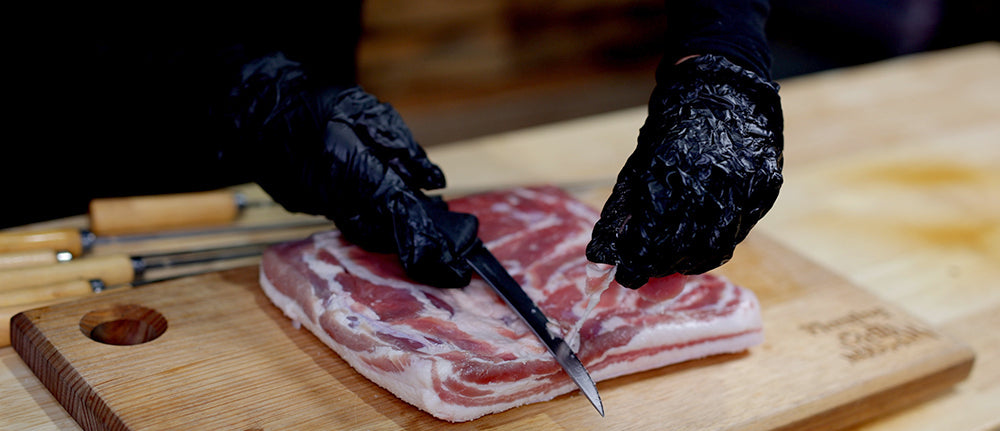 This image shows excess fat of pork belly being trimmed