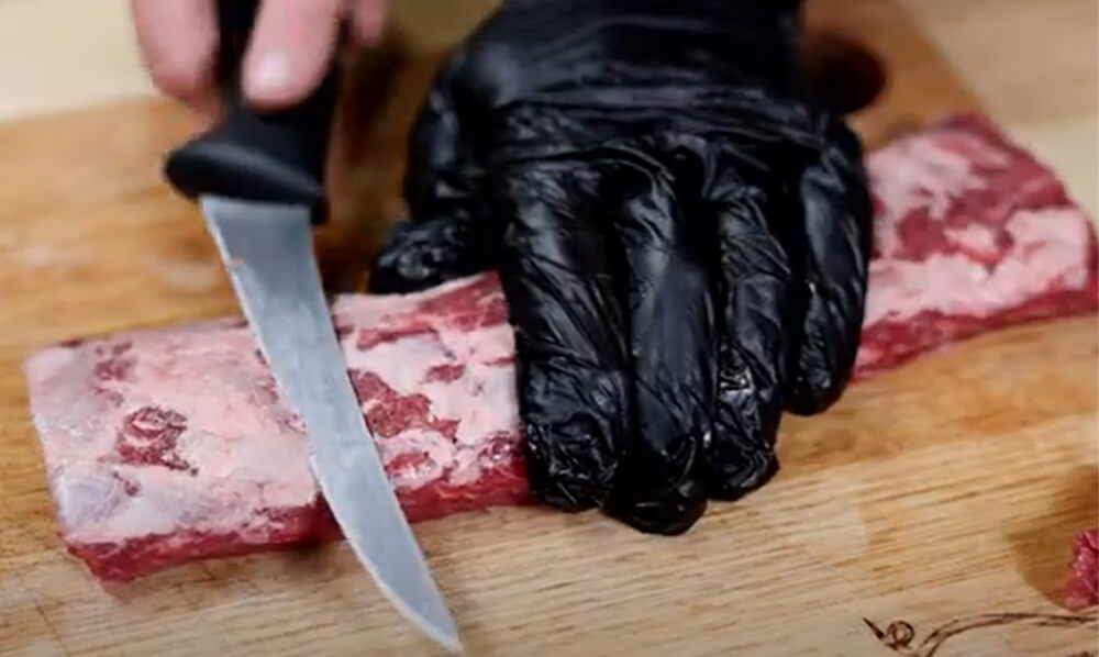 This image shows the excess fat of the lamb being trimmed. 