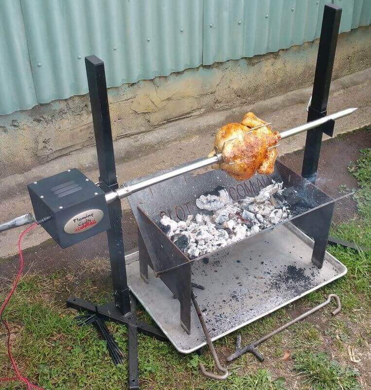 This image shows whole chicken being cooked in Portable Camping Spit