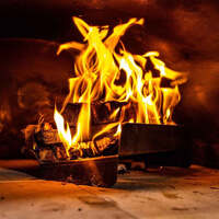 Should I use wood or charcoal when cooking on my Parrilla grill? image